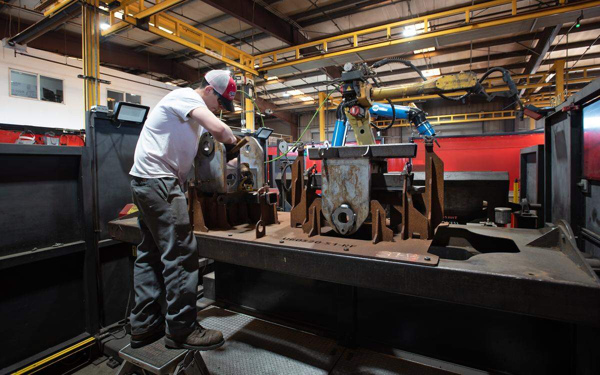 Welder Christian Santana prepares a part for robotic welding at Flory Industries, which makes nut harvesting equipment in Salida, Calif., Thursday, Feb. 9, 2023.