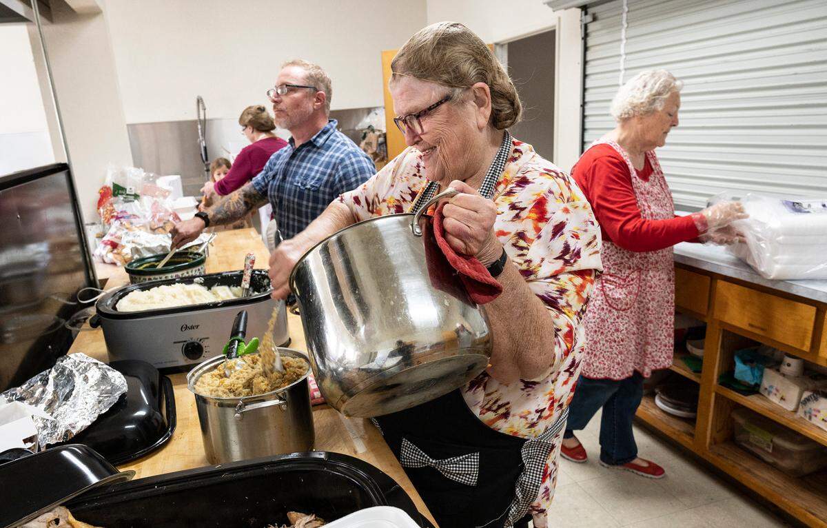 Marlene Jobe transfers stuffing as Waterford Ministerial Association hosted its seventh annual Community Thanksgiving Dinner in Waterford, Calif., on Thursday, Nov. 25, 2021. Meals were picked up in cars only due to COVID-19 precautions.