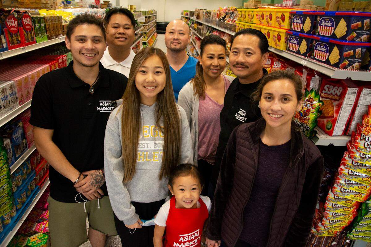 The family of Asian Market owner Trong Vuong inside the speciality grocery store. Pictured cockwise from top left: nephew Alex Vuong, brother That Vuong, wife Kayla Vuong, Trong Vuong, daughters Leena Vuong, Stella Vuong and Alexia Vuong, and son Andrue Vuong.