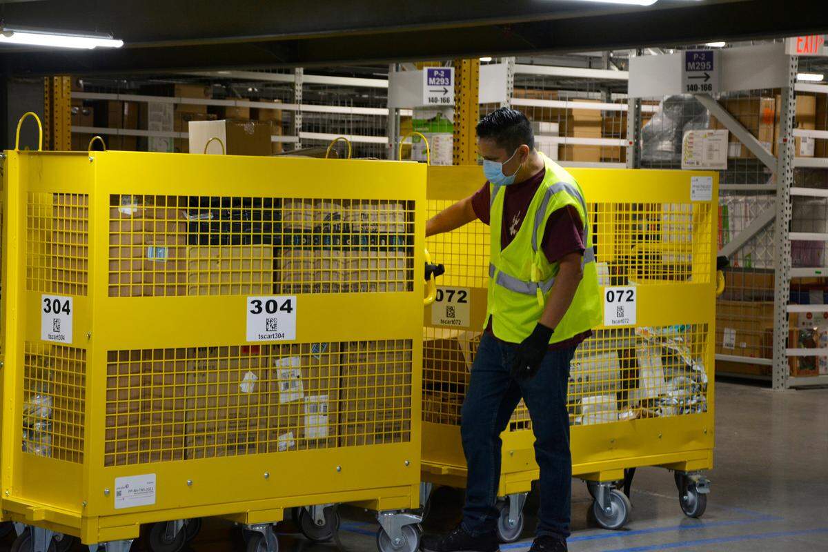 A worker moves items Thursday, Oct. 20, 2022, inside the new Amazon fulfillment center in Turlock, Calif.