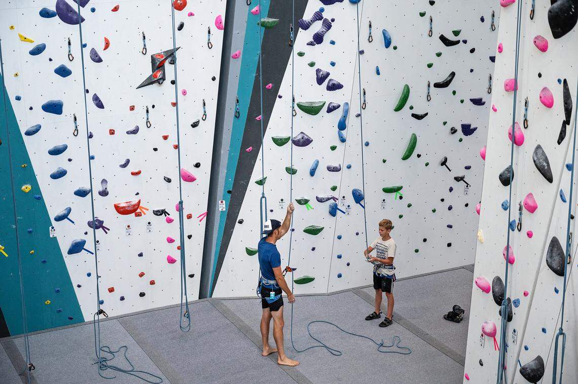 Tytus Born, 11, right, prepares to climb the 55ft. wall with the help of his father Tyler Born at Alpine Climbing Adventure Fitness in Ripon, Calif., on Wednesday, June 30, 2021.