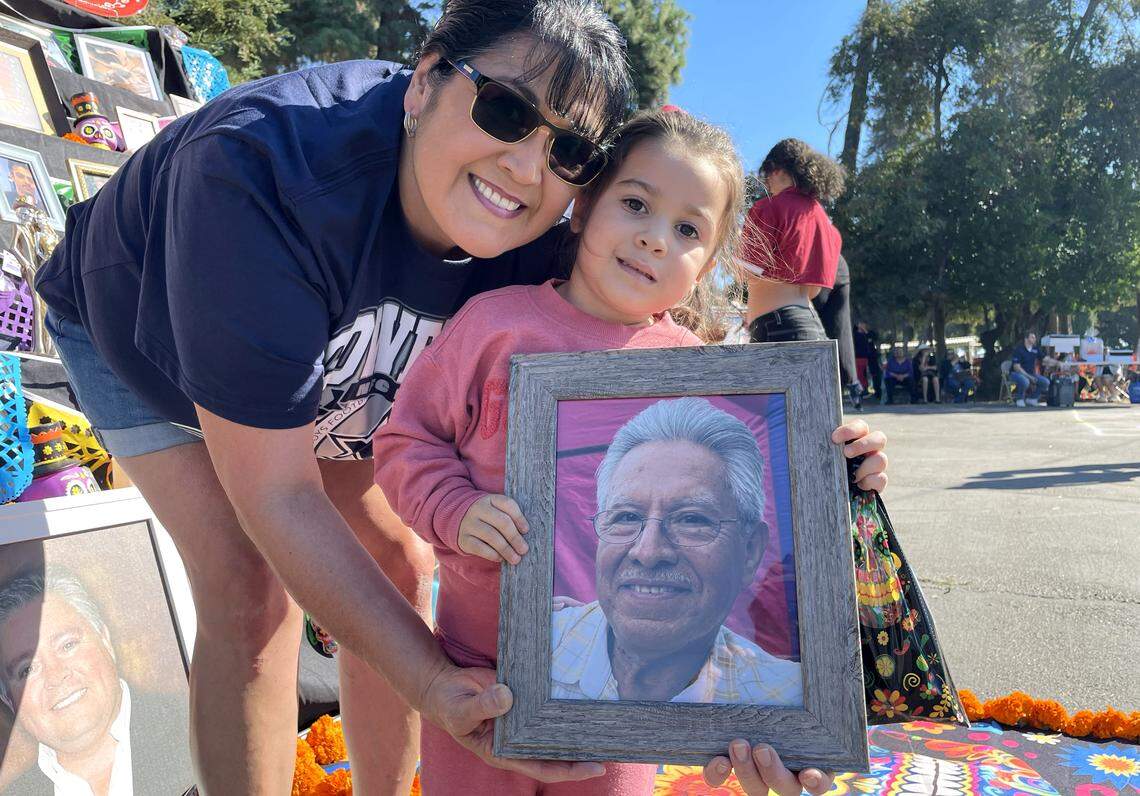 Mireyah Fragua, de 3 años, llevó la imagen de su difunto abuelo, Lucas Solis Yañez, a un evento del Día de los Muertos cerca de Hughson, Calif., el 1 de noviembre de 2025. Contó con la ayuda de su tía Cathy Bedoy-Duenas.