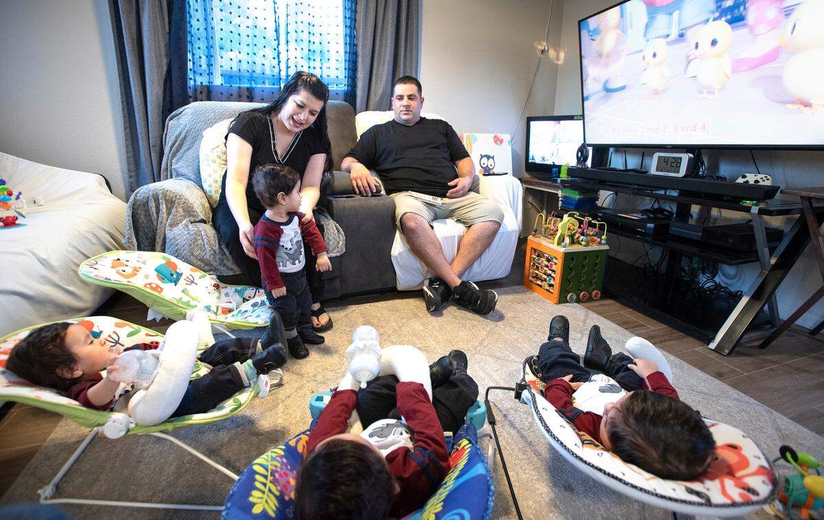 Parents Tania and Rene Villanueva with their 1-year-old quadruplets at their home east of Hughson, Calif., on Thursday, Dec. 16, 2021. Andrew was born at 2:36 p.m. on New Year’s Eve of 2020, followed over six minutes by Julian, Samuel and finally Robert.