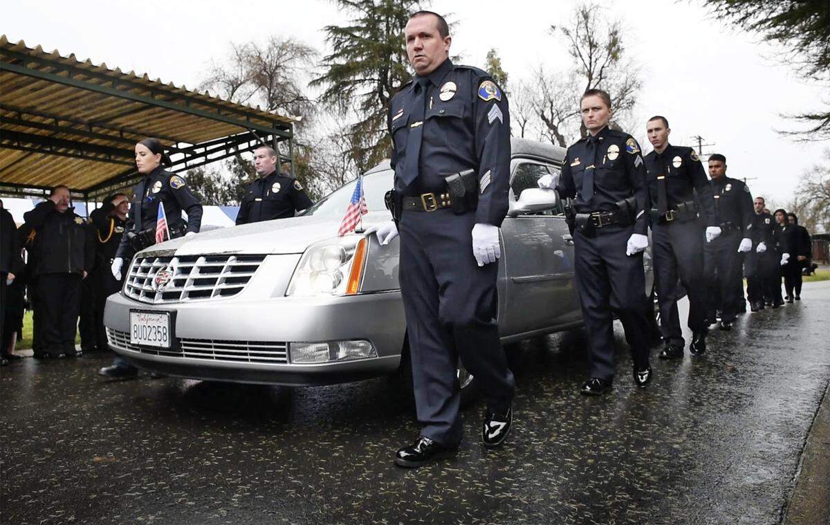Members of the Newman Police Department walk along side the hearse carrying the body of fallen Newman Police Cpl. Ronil Singh at Lakewood Memorial Park in Hughson, Calif., Saturday, Jan. 5, 2019.