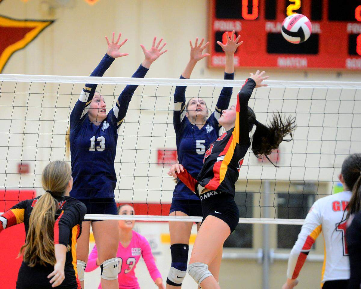 Oakdales Jaedyn Riley hits the ball past Central Catholic’s Marie Wildenberg (13) and Alyssa Thomas (5) during a game between Oakdale and Central Catholic at Oakdale High School in Oakdale, Calif. on Thursday, Oct. 17, 2024.&nbsp;