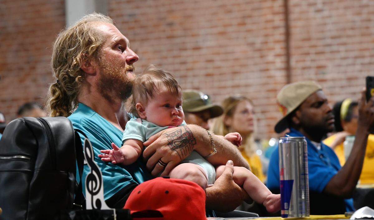 Robert Hensley watches performances with his five-month-old daughter Layona during the Downtown Streets Team talent show at the Martin G. Petersen Events Center in downtown Modesto, Calif., Friday, May 31, 2024.