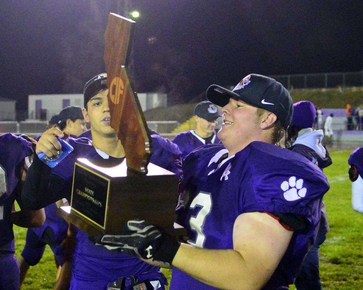 Denair’s Derek Starkey holds the CIF trophy after winning the CIF Division 7-AA championship between Denair and Santee at Denair High School in Denair California on December 1, 2018.
