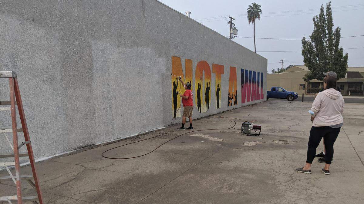 Made in Turlock removes a mural from the side of Harder’s Print Shop in Turlock, Calif. on Sept. 12, 2020. Some residents criticized the mural featuring the message “This is not a wall” as political.