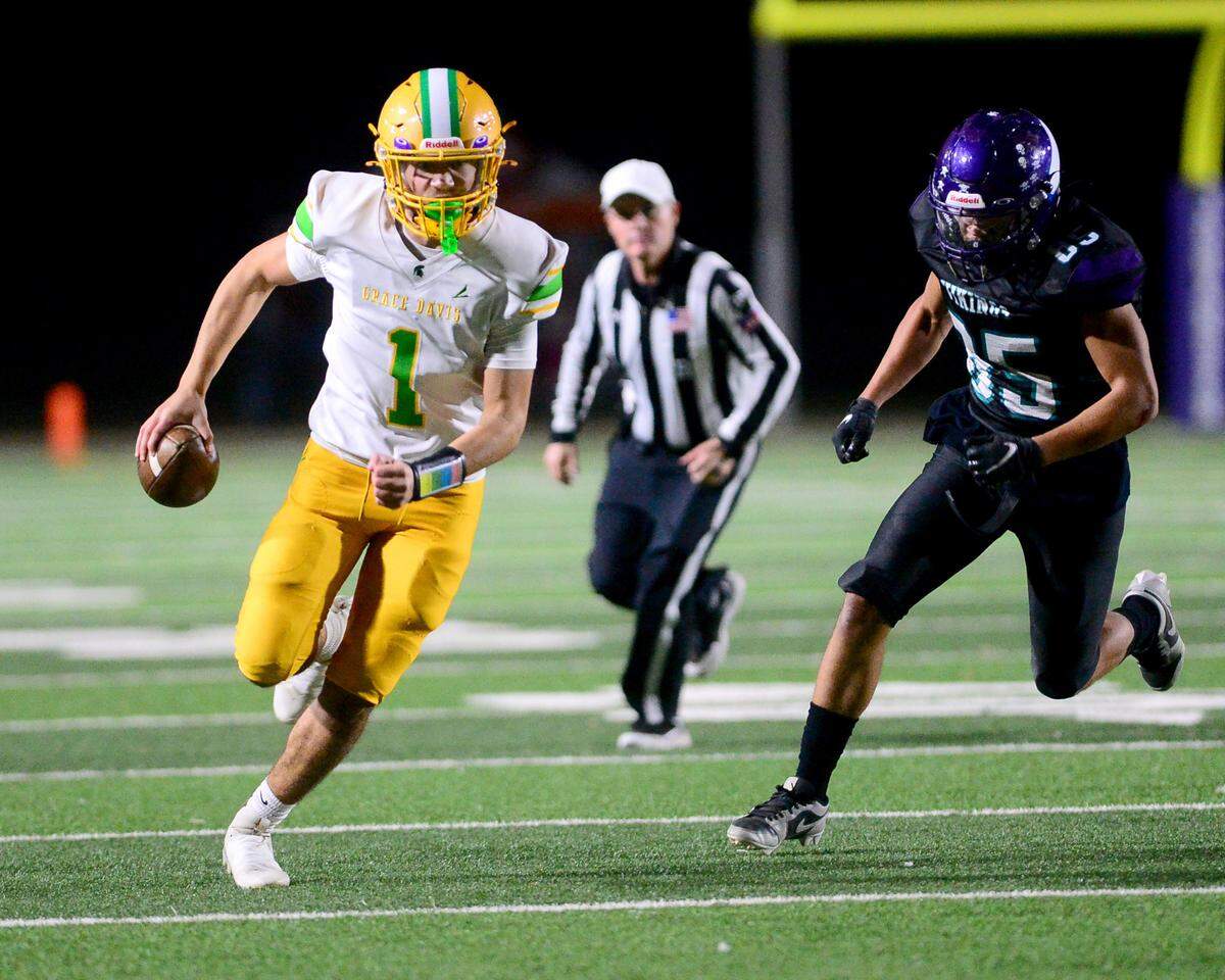 Davis quarterback Caleb Zaragoza (1) scrambles down the sideline during a game between Johansen and Davis at Johansen High School in Modesto California on November 1, 2024.