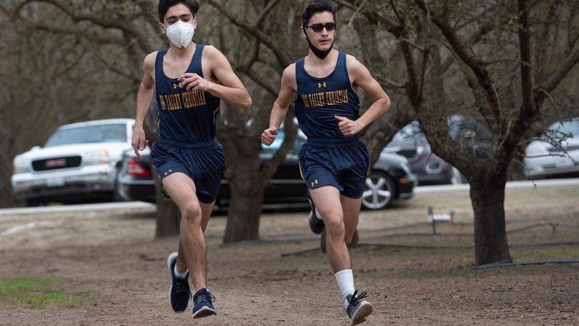 Big Valley Christian cross country runners, brothers Peter Pacheco, left, and Robert Pacheco, right, start the 3-mile race west of Modesto, Calif., on Tuesday, Feb. 9, 2021. Several private schools participated in a cross county meet in an almond orchard west of Modesto. Robert finished with a time of 18:11, and Peter finished at 19:24.