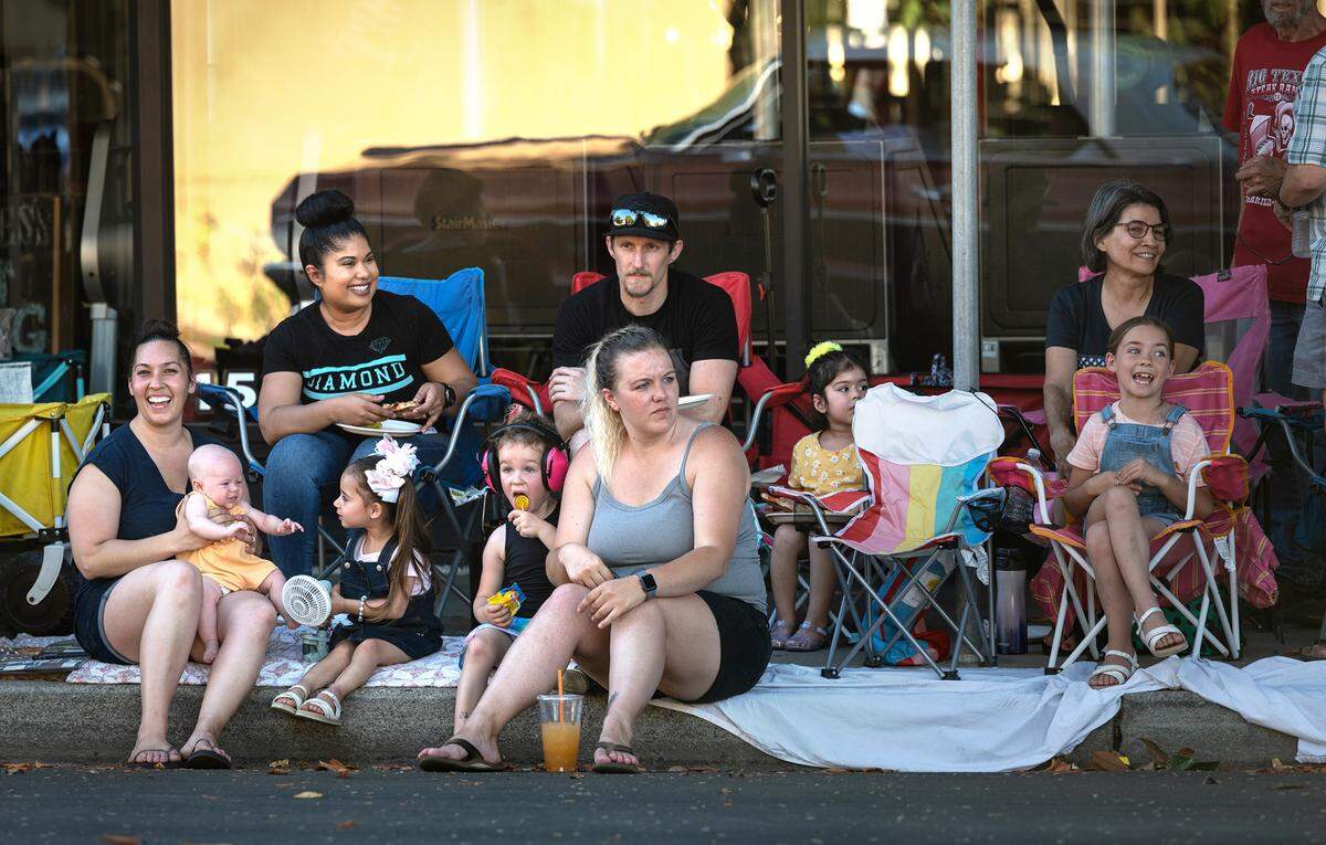 Spectators watch classic cars roll by on J Street during the North Modesto Kiwanis Club’s “American Graffiti” car parade in Modesto, Calif., on Friday, June 10, 2022.