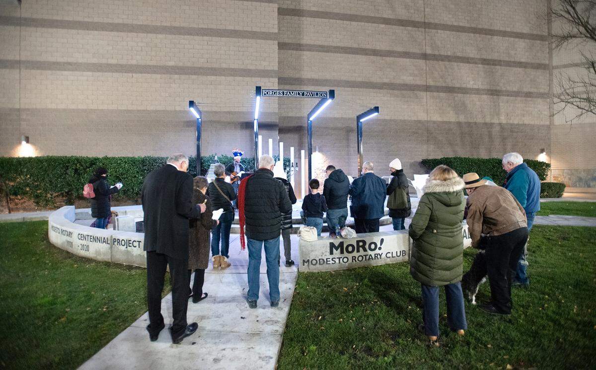 A small group sings with Congregation Beth Shalom Rabbi Shalom Bochner during the lighting of the menorah on the third day of Hanukkah outside the Gallo Center for the Arts in Modesto, Calif., Tuesday, Dec. 20, 2022.