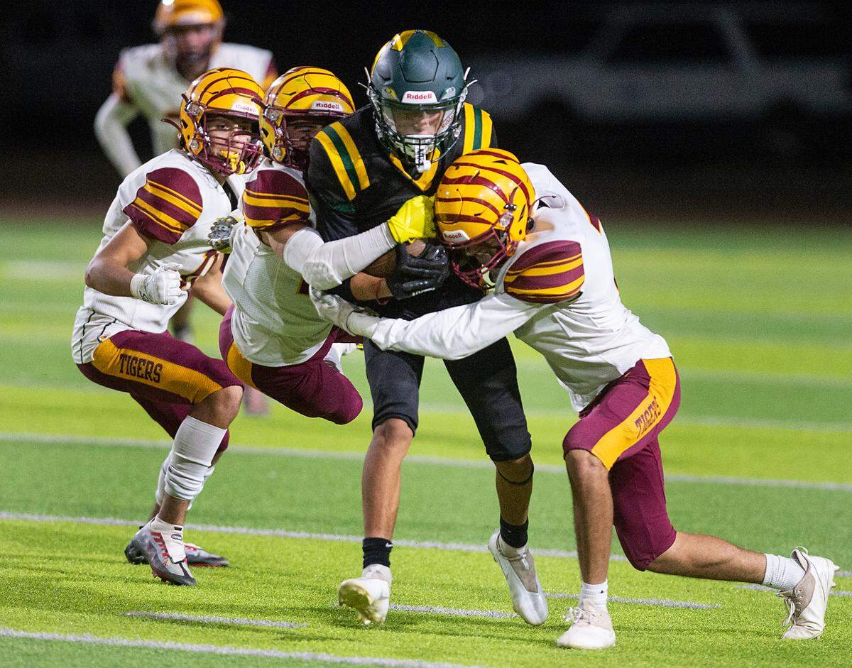 Los Banos defenders Joel Alvarenga, right, and Mark Carreiro wrap up Davis’ Izrael Sanchez during a Western Athletic Conference game at Downey High School in Modesto, Calif., on Friday, September 23, 2022.