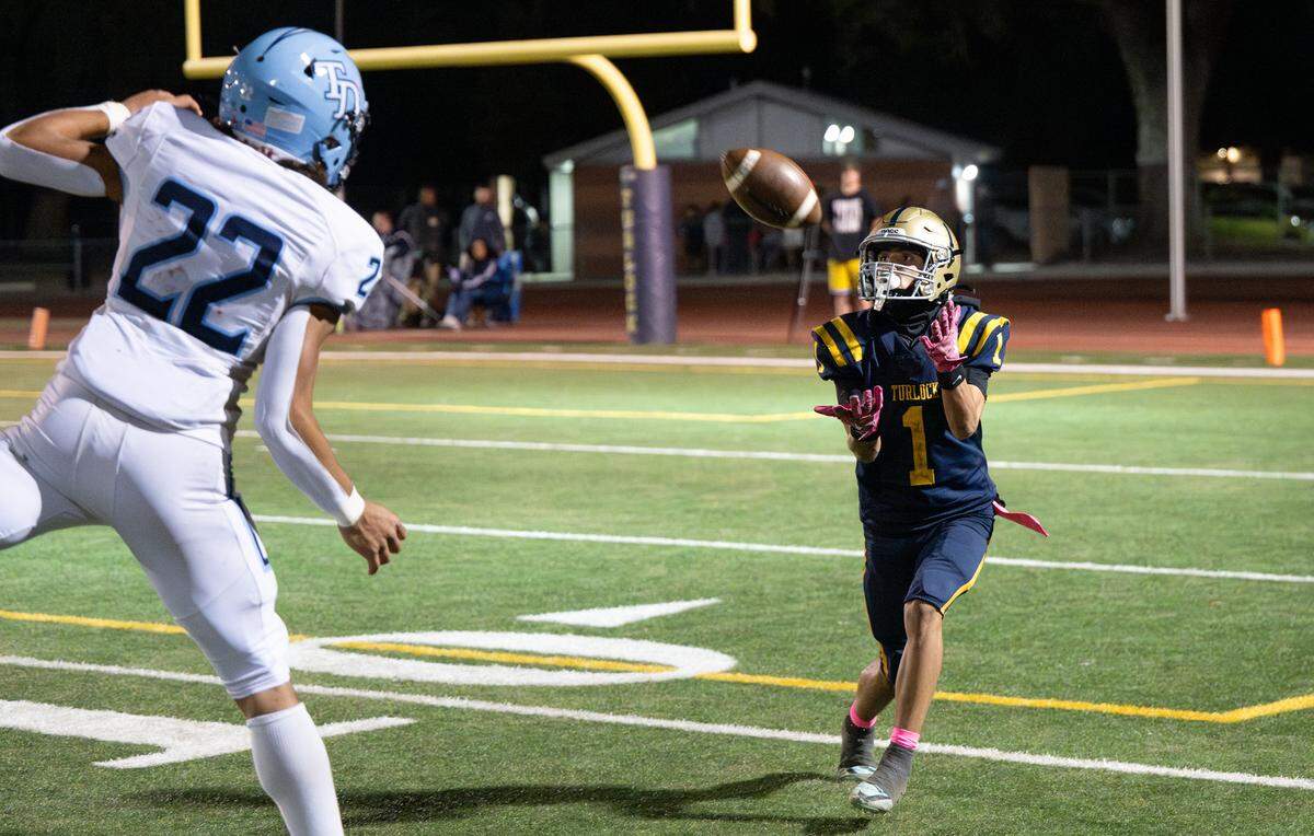 Turlock’s Jr. Silva makes a catch and runs the ball in for a touchdown during the Central California Athletic League game with Downey at Turlock High School in Turlock, Friday, Oct. 18, 2024.
