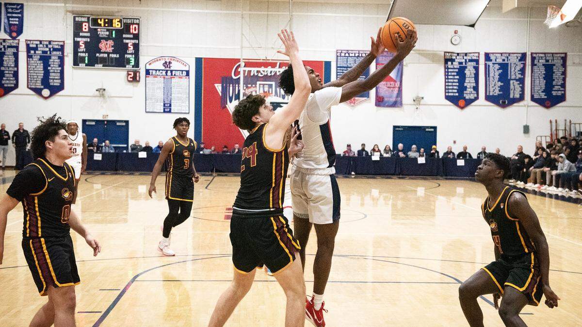 Modesto Christian’s Jalen Brown scores on a layup past Clovis West’s Cooper Villi during the Modesto Christian Holiday Hoop Classic championship game at Modesto Christian High School in Salida, Calif., Friday, Dec. 30, 2022. MC won the game 79-55.