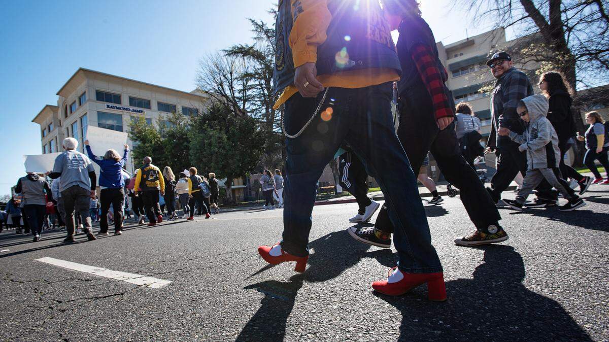 Participantes reccorren I Street durante la caminata de recaudación de fondos In Their Shoes para HAVEN en Modesto, California, el sábado 1º de abril de 2023. HAVEN (Healthy Alternatives to Violent Environments) ofrece servicios de apoyo a víctimas de violencia doméstica, agresión sexual y tráfico de seres humanos en el Condado de Stanislaus.