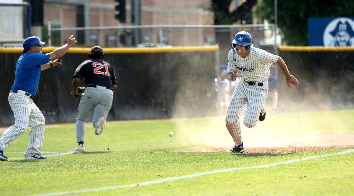 Modesto’s Troy Morrow scrambles home on a wild throw after stealing third base during the Northern California Regional playoff game with Reedley at Modesto Junior College on May 1, 2026. Modesto won the game 6-5.