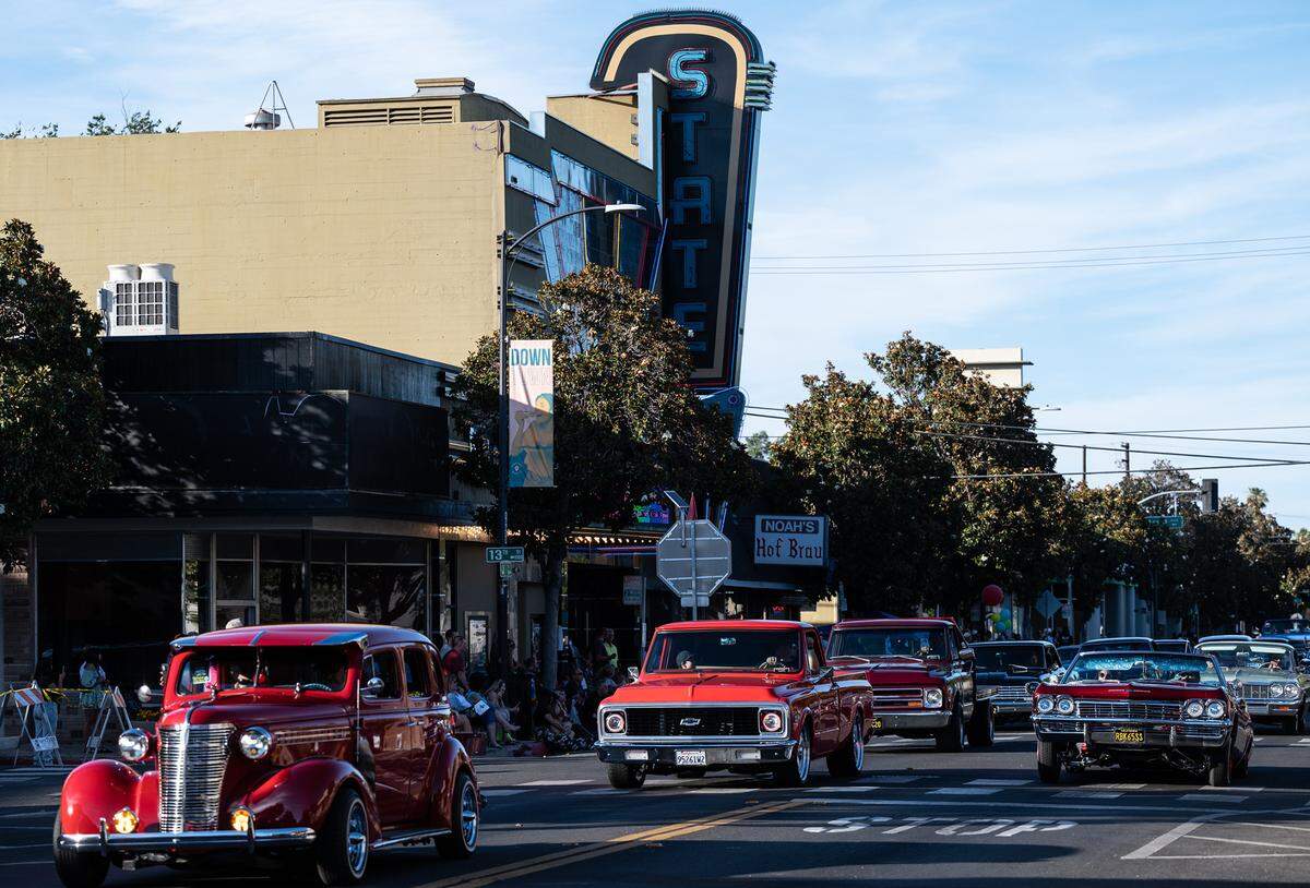Classic car owners drive past the State Theatre during the “American Graffiti” car parade in Modesto, Calif., on Friday, June 10, 2022.