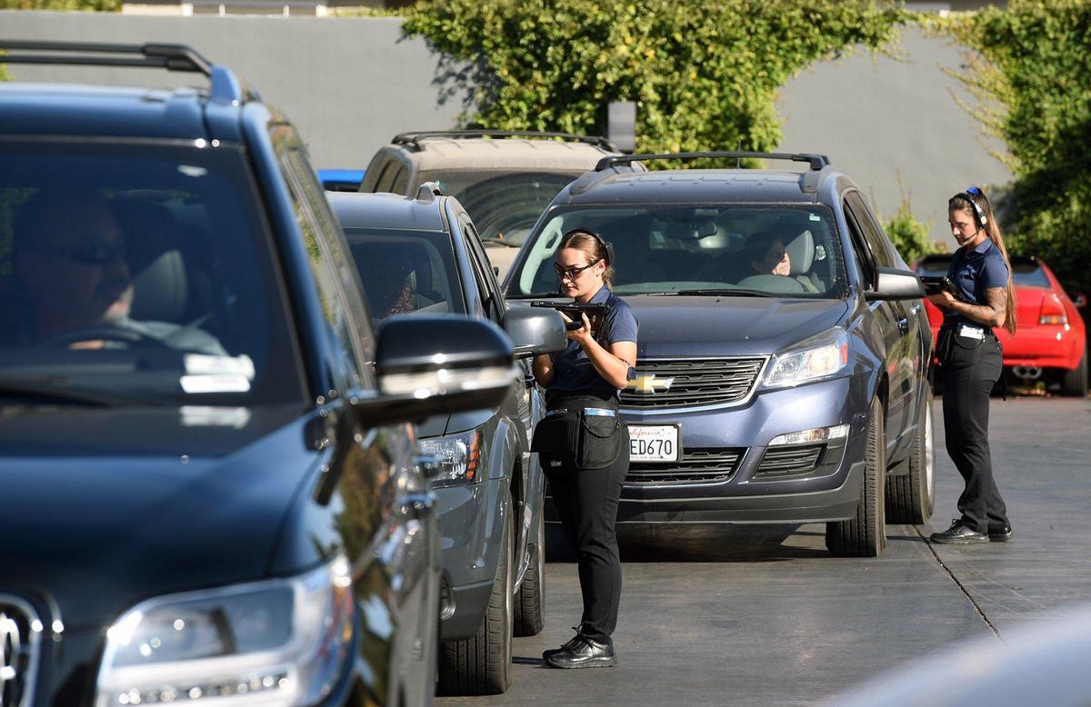 Customer service advisors Kenadee Stockton and Jocelyn Walle (right) help customers in vehicles at Mister Car Wash Friday afternoon October 25, 2019 on McHenry avenue in Modesto, Calif.