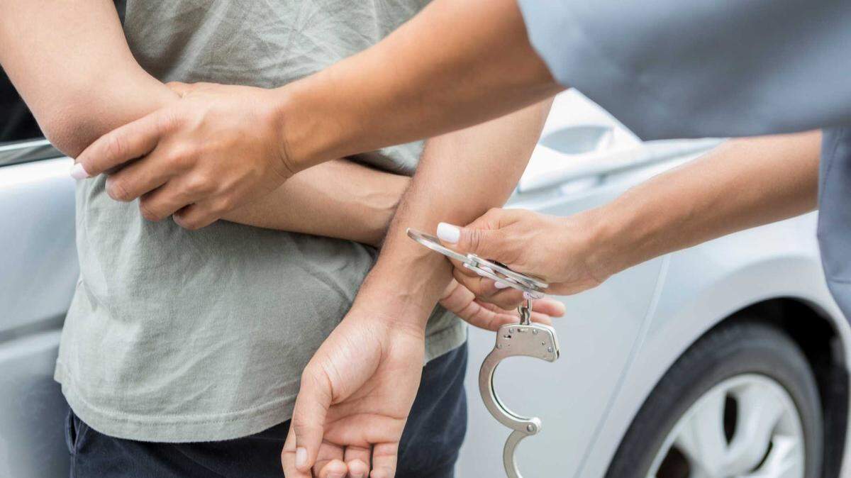 A person being placed in handcuffs, illustrative of an arrest.