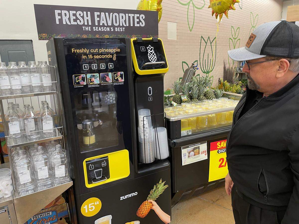 Vice President of produce and floral, Mike Veneziano demonstrates Save Mart’s new pineapple cutting machine at the grand re-opening of Save Mart in Riverbank on Thursday, Sept. 12.