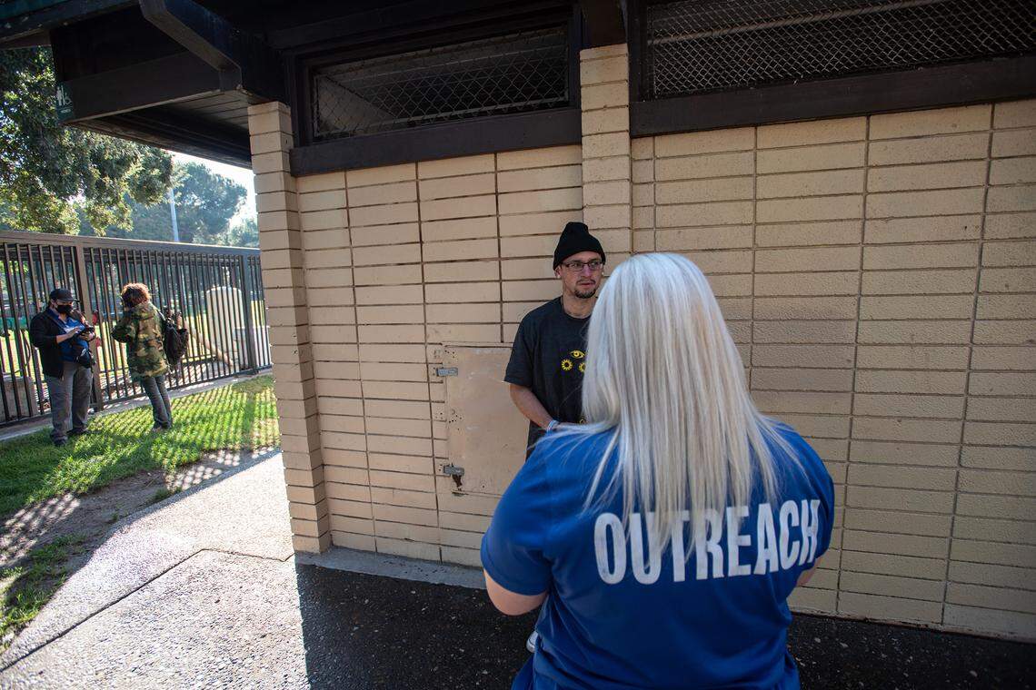 Community Health and Assistance Team (CHAT) outreach specialist Veda Malone talks with Jarrod Switzer at Davis Park in Modesto Calif., on Wednesday, Nov. 3, 2021.