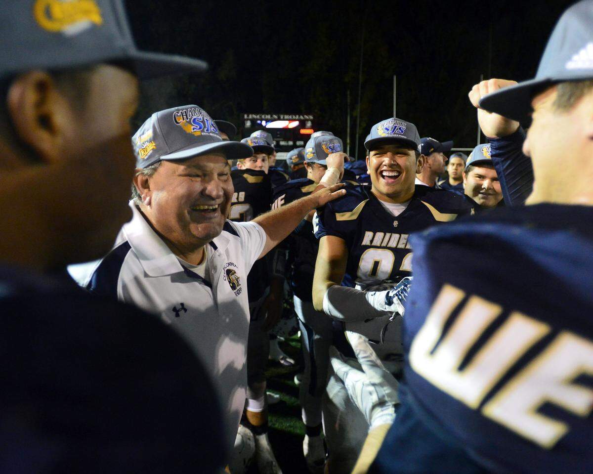 Central Catholic head coach Rodger Canepa (left) smiles with his team after winning the Division III Championship game between Oakdale and Central Catholic, where Central Catholic won 21-7 at Lincoln High School in Stockton on Dec 4, 2015.  
