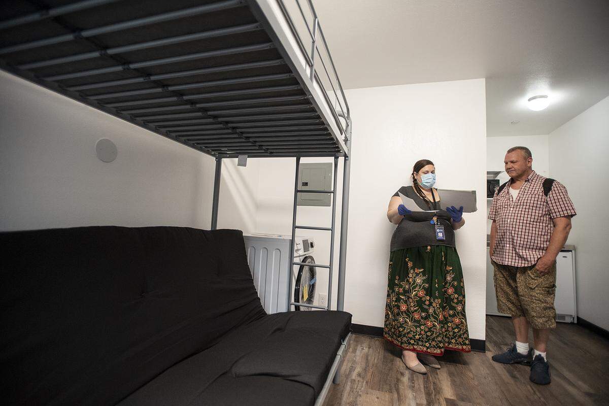 Resident Rodney Abel, right, goes over the lease agreement with Barbara Phal at Kansas House in Modesto, Calif., on Friday, May 29, 2020. Kansas House, a former 103-room Modesto budget motel, was converted into permanent supportive housing for homeless people.