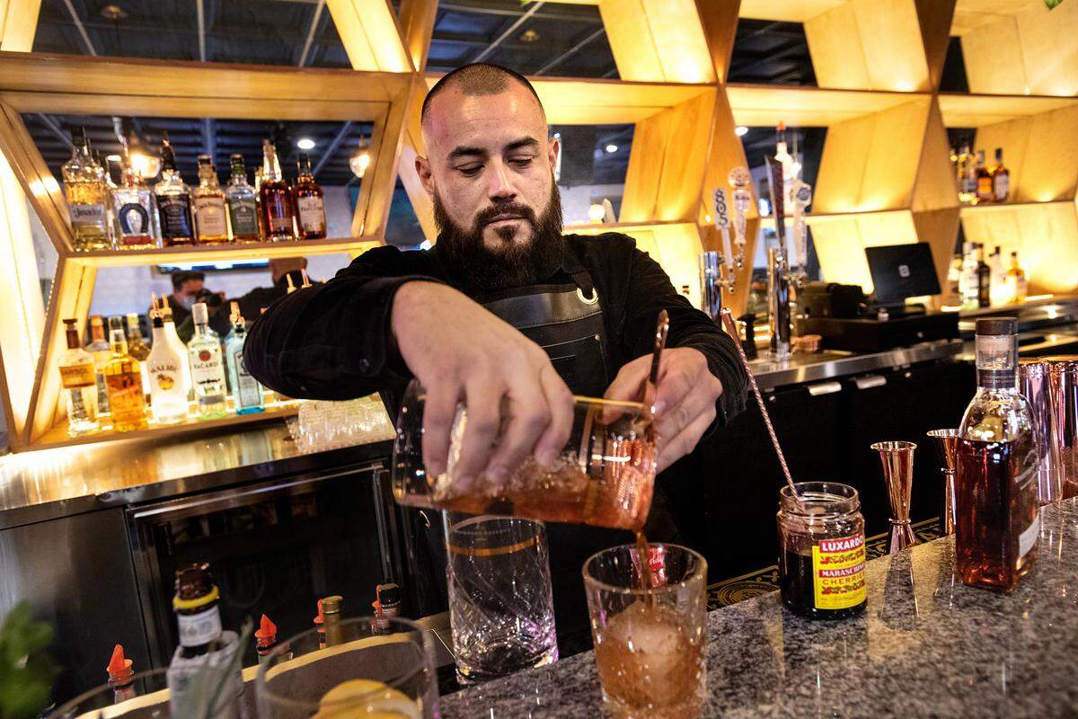 Lead bartender Noah Tamez makes an Old Fashioned mixed drink at Spotlight Ultra Lounge in downtown Modesto, Calif., on March 10, 2022.