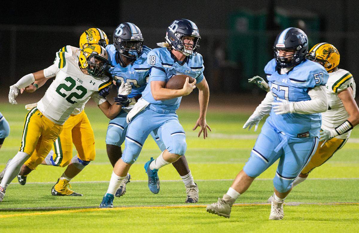 Downey quarterback Conner Stoddard scrambles for a short gain during the nonleague game with Tracy at Downey High School in Modesto, Calif., on Friday, September 16, 2022.