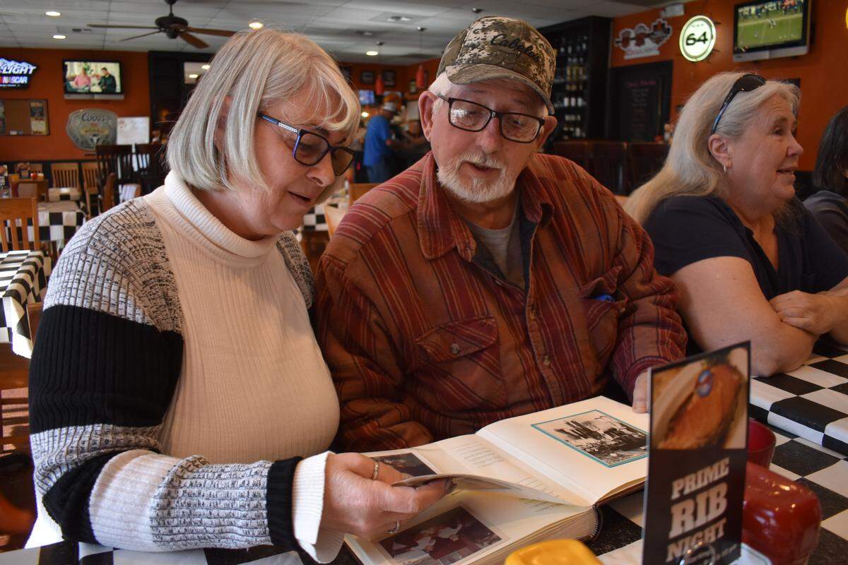 Jo Ann Beukelman and her father, Tony Cardoza, look at a photo album during a family lunch at Shorty’s Sports Pub & Grill in Escalon on Sunday, Nov. 24, 2019.