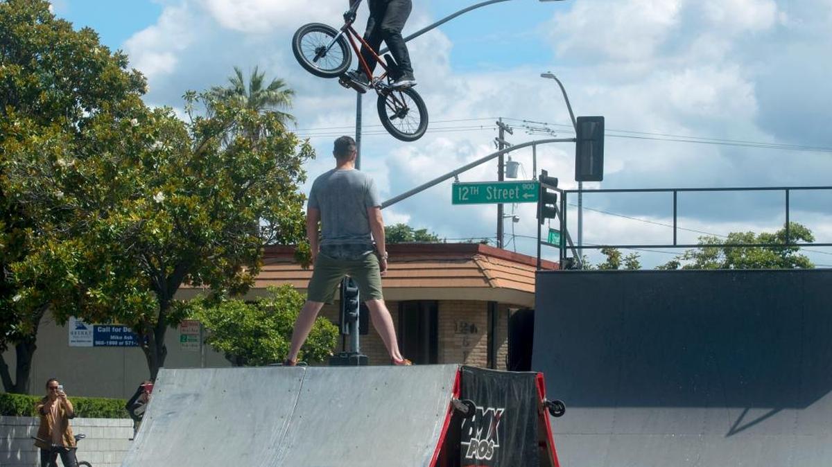 A stunt performer jumps over a volunteer during the 2016 Modesto Family Cycling Festival in downtown Modesto.