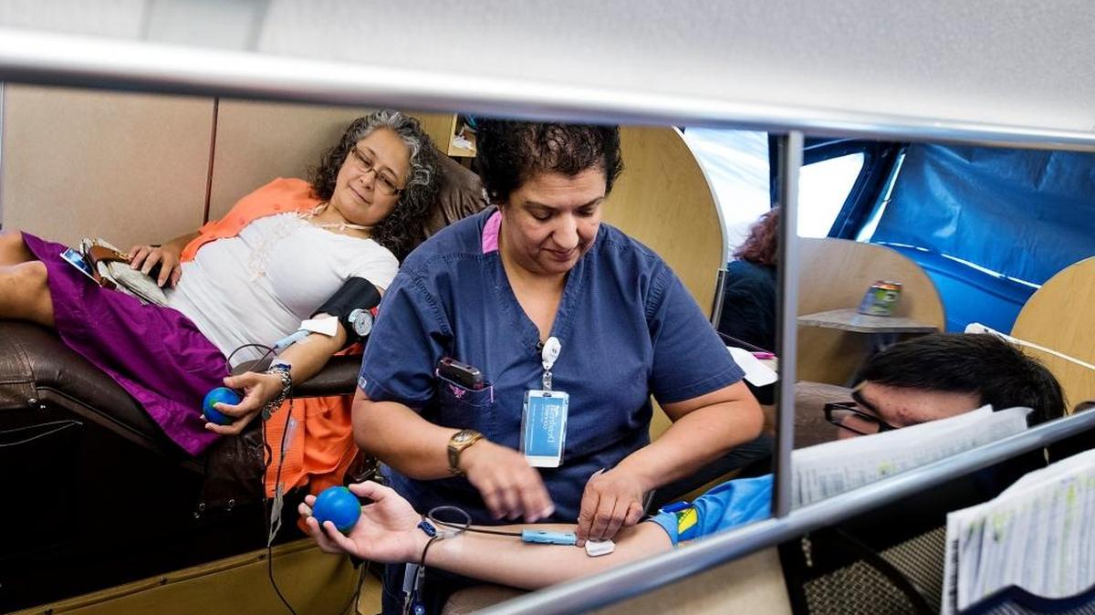 Registered nurse Maria Vega, middle, tends to Will Hinrichs as heand Lupe Valdez, left, have their blood drawn on a BloodSource mobile donation bus at Regal Cinemas on McHenry Ave in Modesto last March. . Each donor gives a pint of blood; and afterward, they received a free movie ticket.