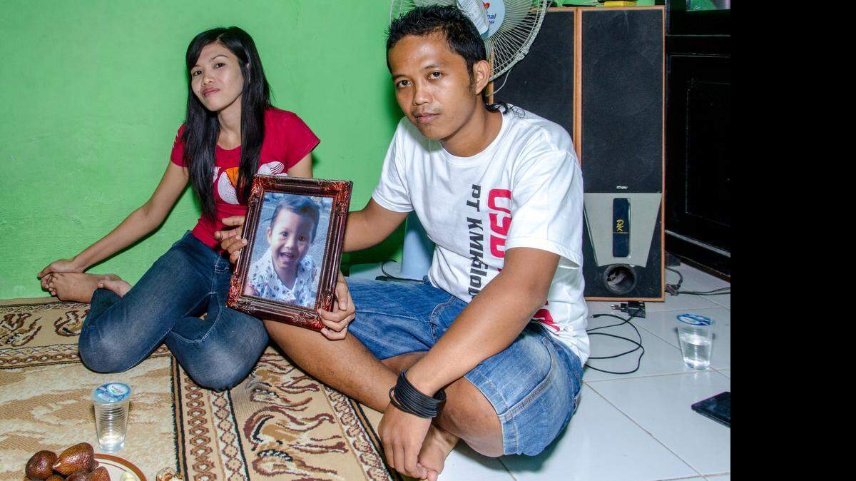 
Sutikna and Dewi hold a picture of their daughter, who lives on the other side of Java with her grandmother. I’m missing my daughter so much. We see her about four times a year,” he said.
