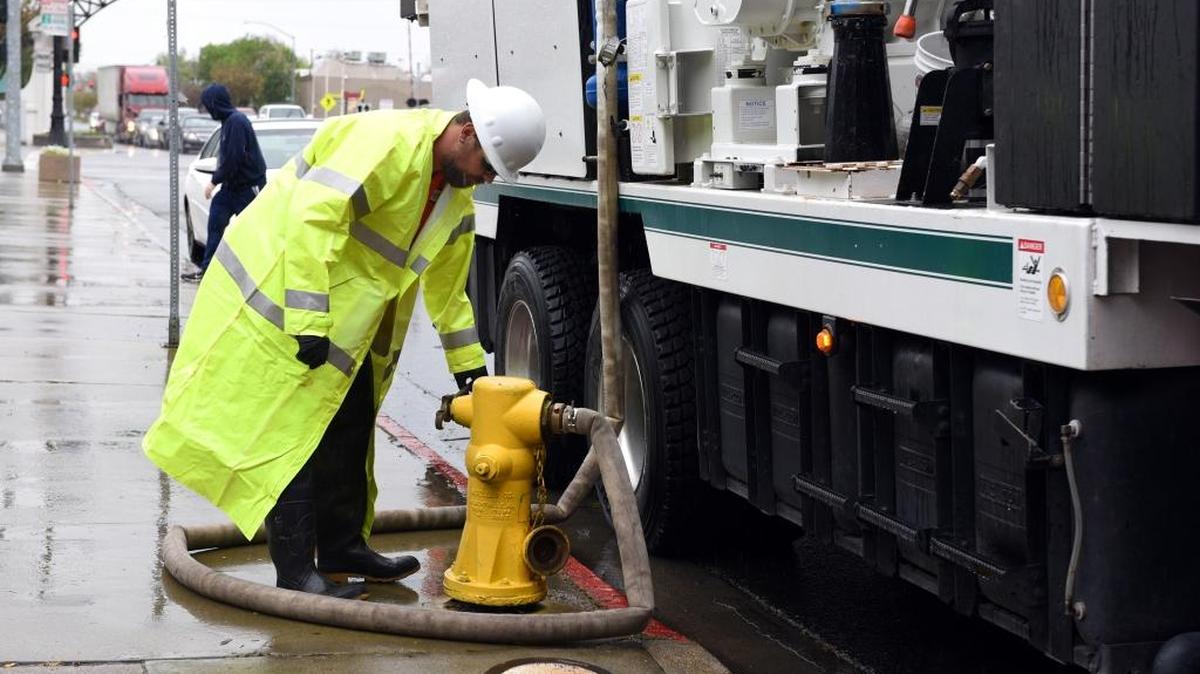 Kevin Boggan with the city of Modesto tops off a tank on his Vac-Con truck Friday morning, March 11, 2016, in the rain on I Street in downtown. The truck is used to drain large puddles of water from city streets.