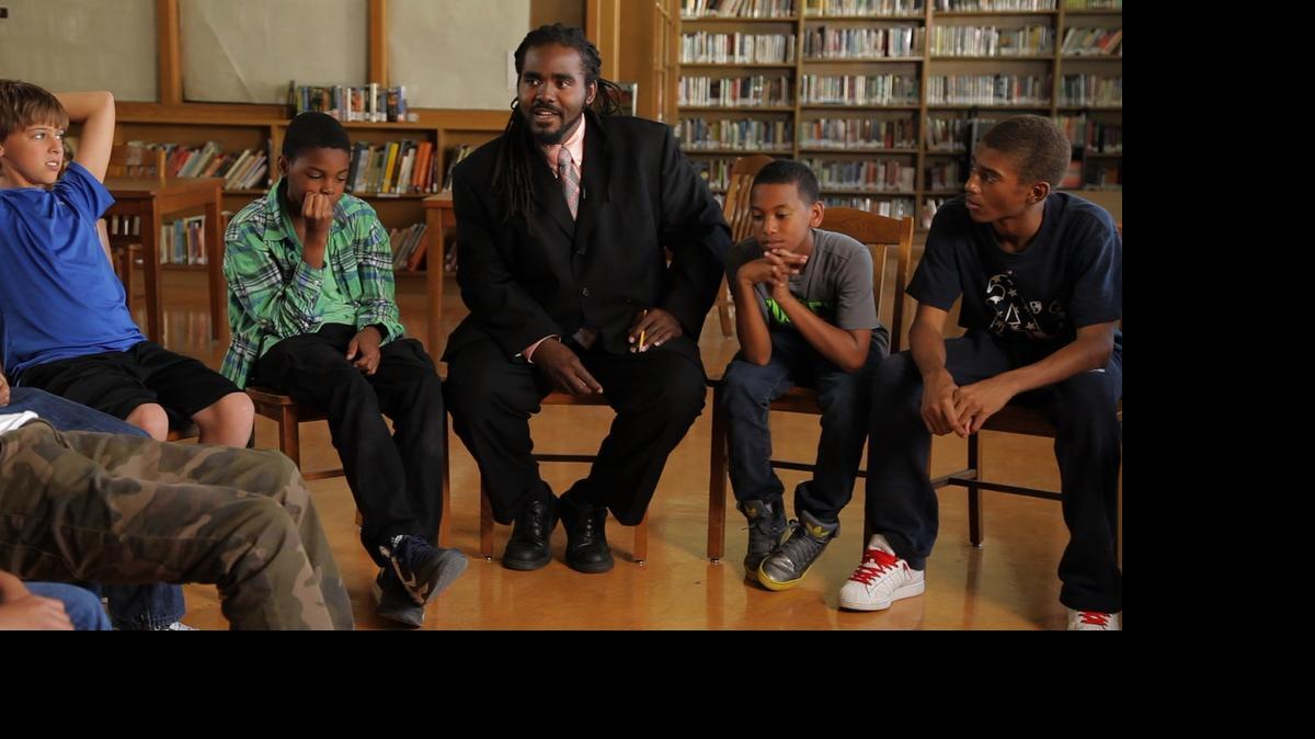 
In a scene from the film “The Mask You Live In,” about our culture’s definition of masculinity, educator Ashanti Branch, center, meets with young men from his mentorship group in Oakland.
