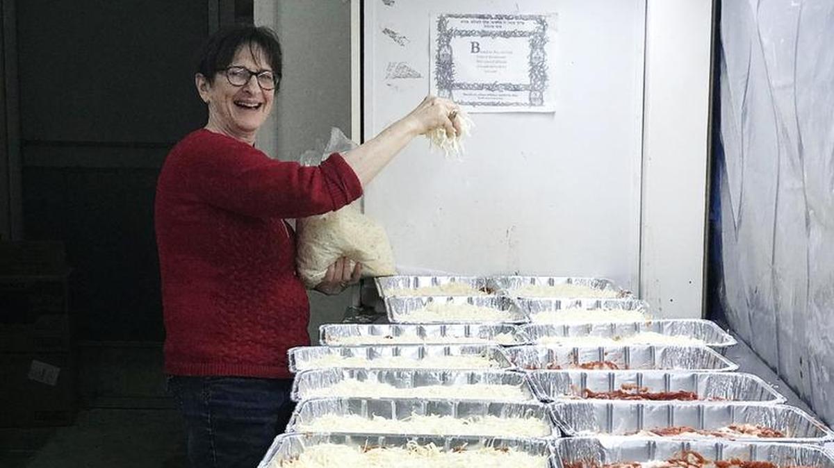 Miriam Bermann helps prepare lasagne at Congregation Beth Shalom for the 10th annual First Responder's Christmas dinner.