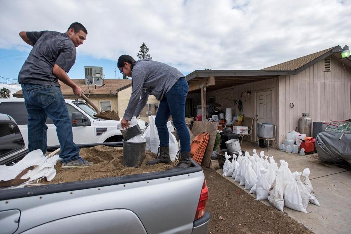 In this 2017 file photo, Jesus Bautista and niece Natalie Gomes fills sandbags at Bautista’s home on Vivian Road in Modesto.