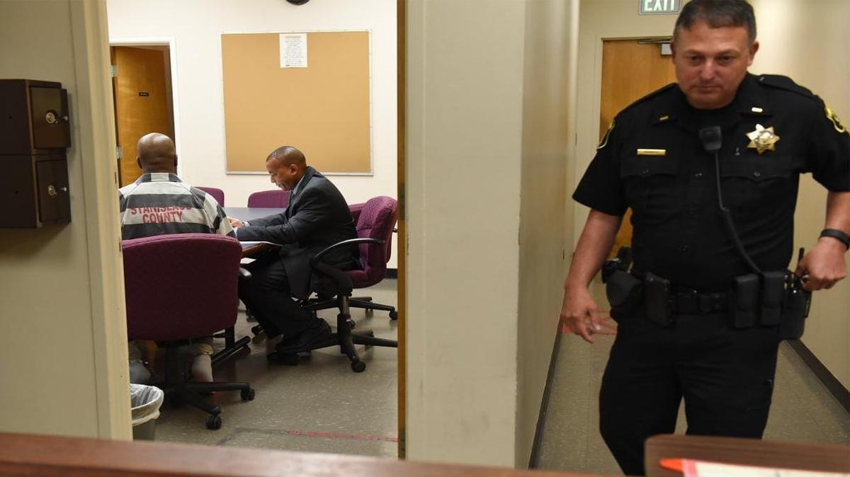 Lt. John Walker, right, walks down a hallway as attorney Marcus Mumford, left, consults with his client Thursday morning, Aug. 4, 2016, at the Stanislaus County Courthouse in downtown Modesto, Calif.