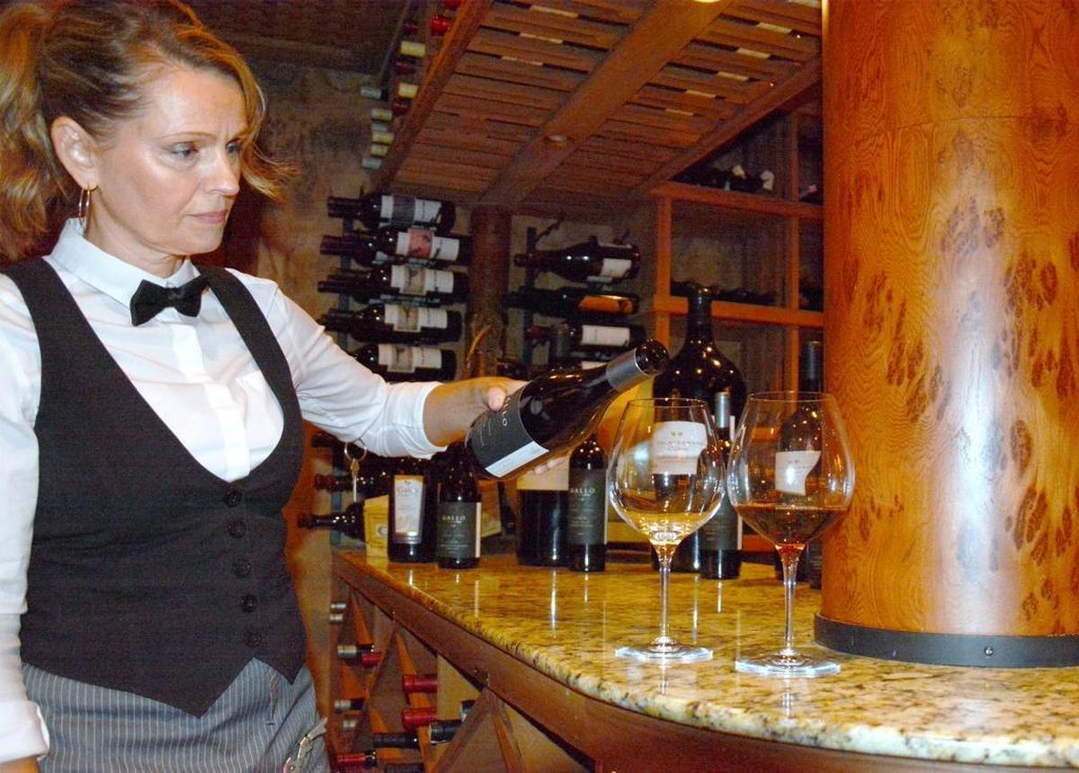 Galletto Ristorante lead bartender Sandra Ruckteschler pours a glass of Gallo Signature Series Pinor Noir in the restaurant’s wine cellar (9-21-17) in Modesto, Calif.
