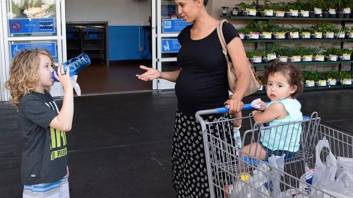 Jesse White, 8, drinks from a reusable water bottle outside Walmart on McHenry Avenue in Modesto on Tuesday, April 19, 2016, as his mom, DeAndra Brown, talks to him. In the cart is DeAndra Brown’s little sister, 18-month-old Addie Ibanez.