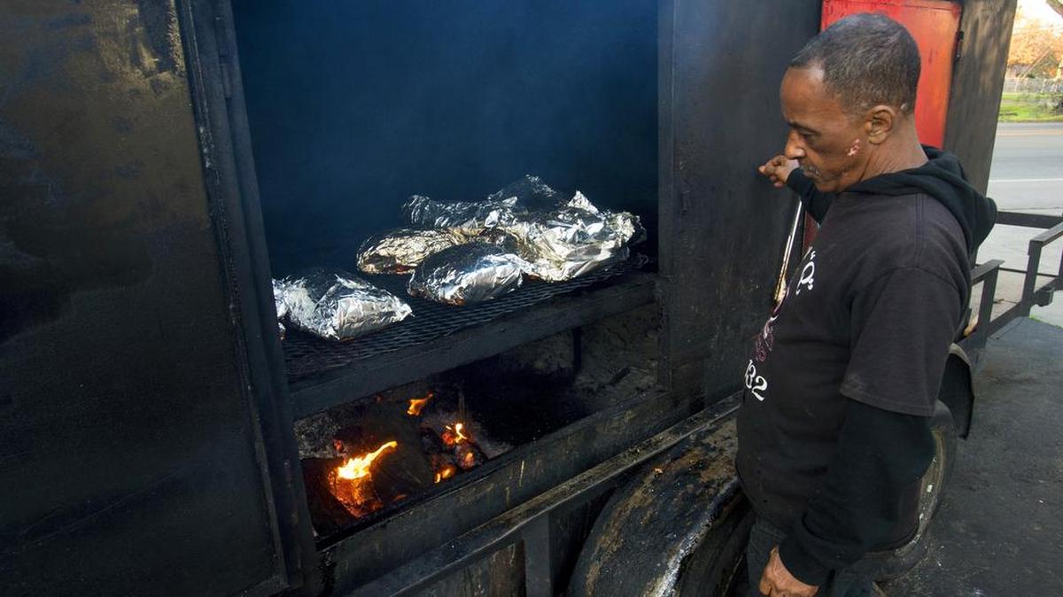 Derek “Doc” Taylor looks at his barbecue pit outside Doc’s Q’in Pit Stop in Modesto on Wednesday, Dec. 23, 2015.