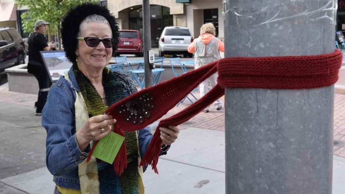 Janice Johnson of Pioneer ties a scarf to a traffic signal post at 10th and J streets Friday morning, April 8, 2016. A “yarn bombing” – affixing scarves and other fabric items to lampposts, bike racks, door handles and other fixtures – happened Friday morning in downtown Modesto to draw attention to the Conference of Northern California Handweavers’ “Field to Fiber” gathering at Modesto Centre Plaza this weekend.