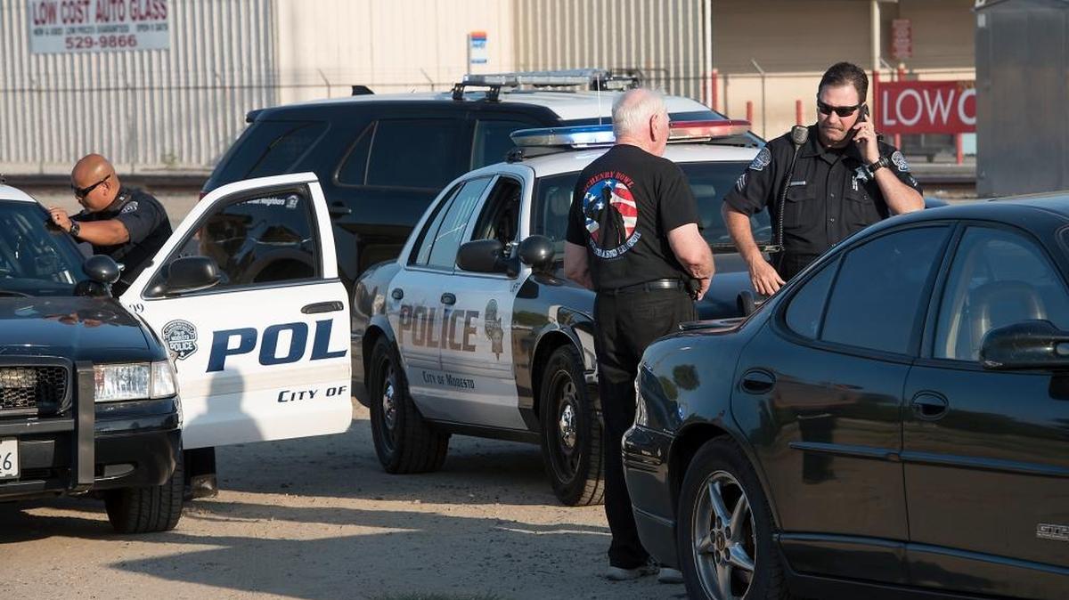 Modesto Police officers question a man after an officer’s vehicle was struck during a separate accident investigation on Yosemite Boulevard in Modesto, August 9, 2017.