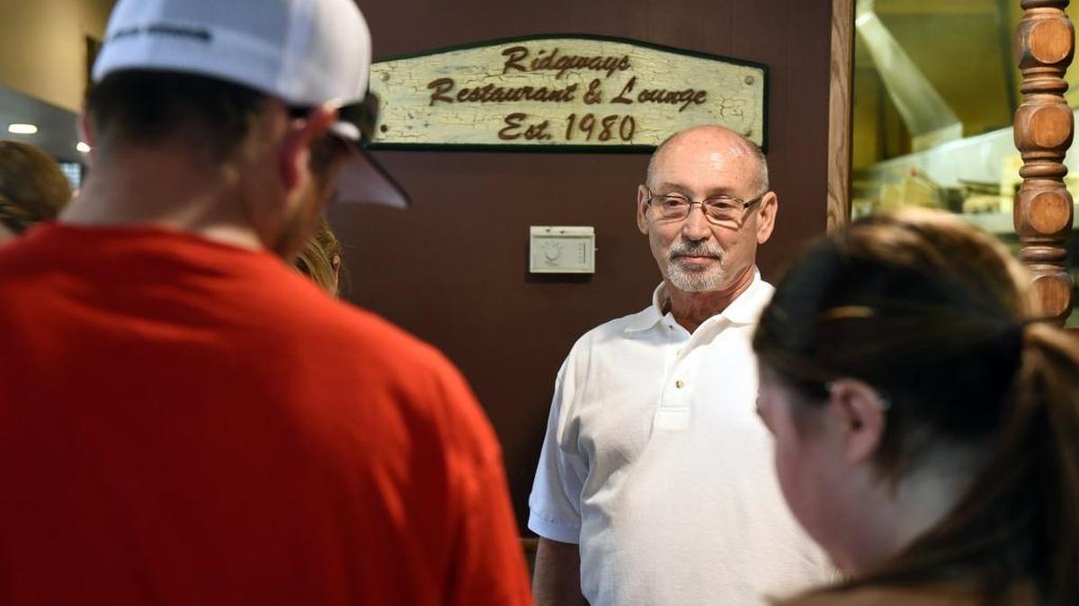 Longtime Ridgway’s founder and owner Roy Ridgway is pictured with customers Wednesday (08-02-17) at Ridgway’s Restaurant & Lounge. The business has been sold by Ridgway to the owners of Sandy’s Sweet Shop.