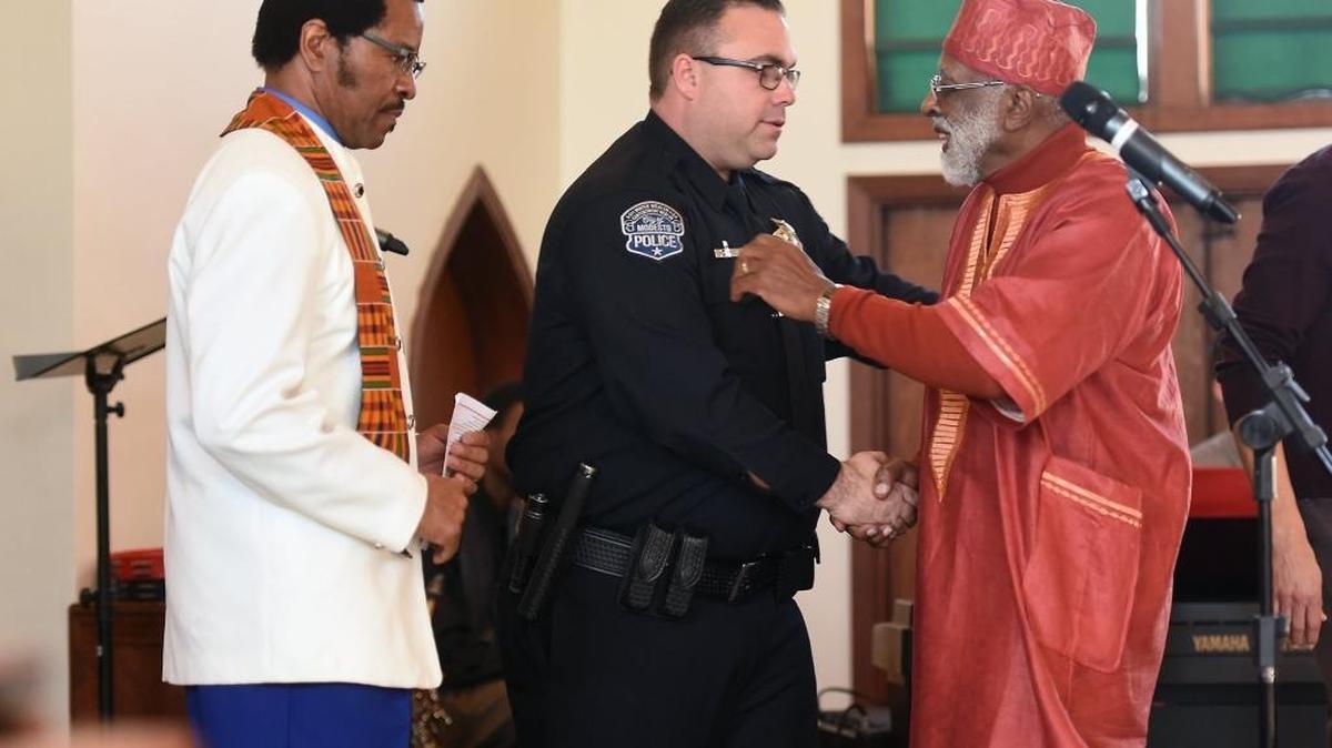 The Rev. Darius Crosby, left, and pastor James M. Anderson of the Modesto Police Clergy Council honor Officer Michael Hammond with an award during the Martin Luther King Day ceremony at Christian Love Baptist Church in Modesto in January.