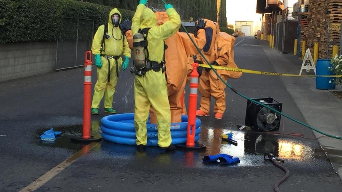 Firefighters are decontaminated after working to contain an ammonia leak at the Bronco Winery near Ceres.