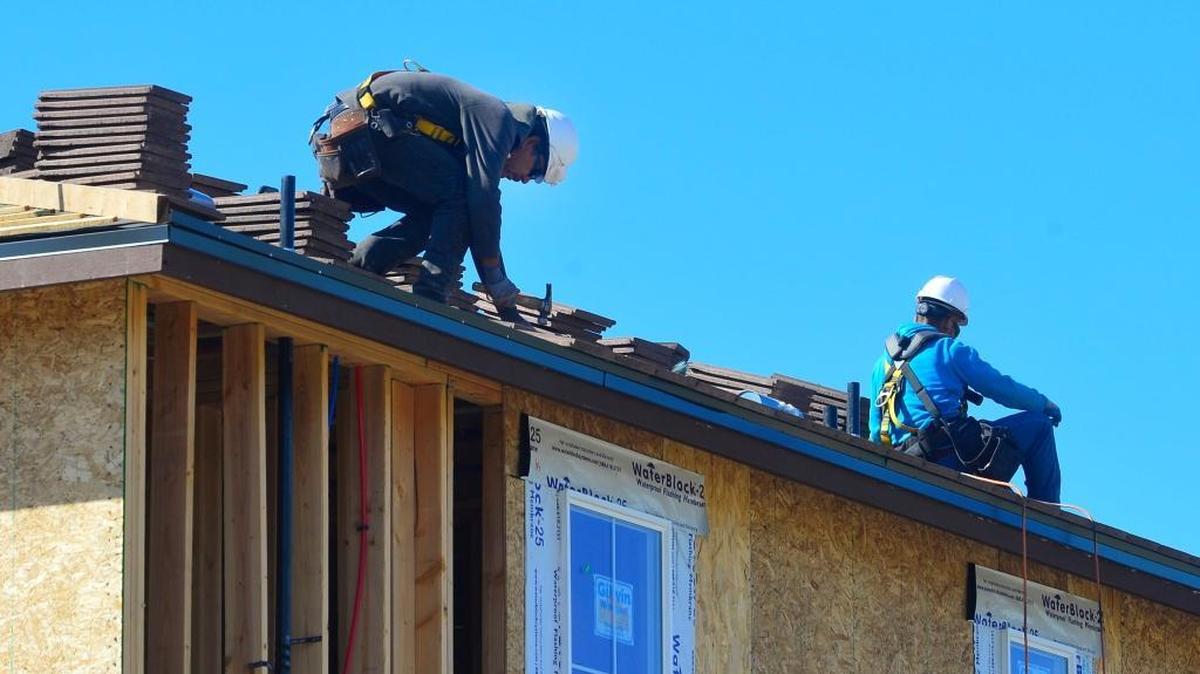 Construction workers place roofing material on new houses at Oakdale Road and Mable Avenue in Modesto in March.