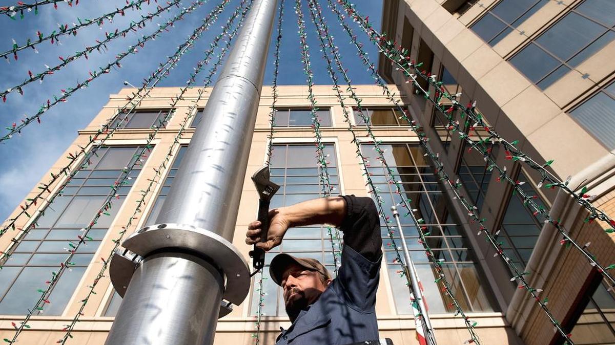 Nick Crockett tightens a fixture during installation of a tree of lights for the Rockin’ Holidays at 10th Street Plaza in Modesto on Tuesday, Dec. 1, 2015.