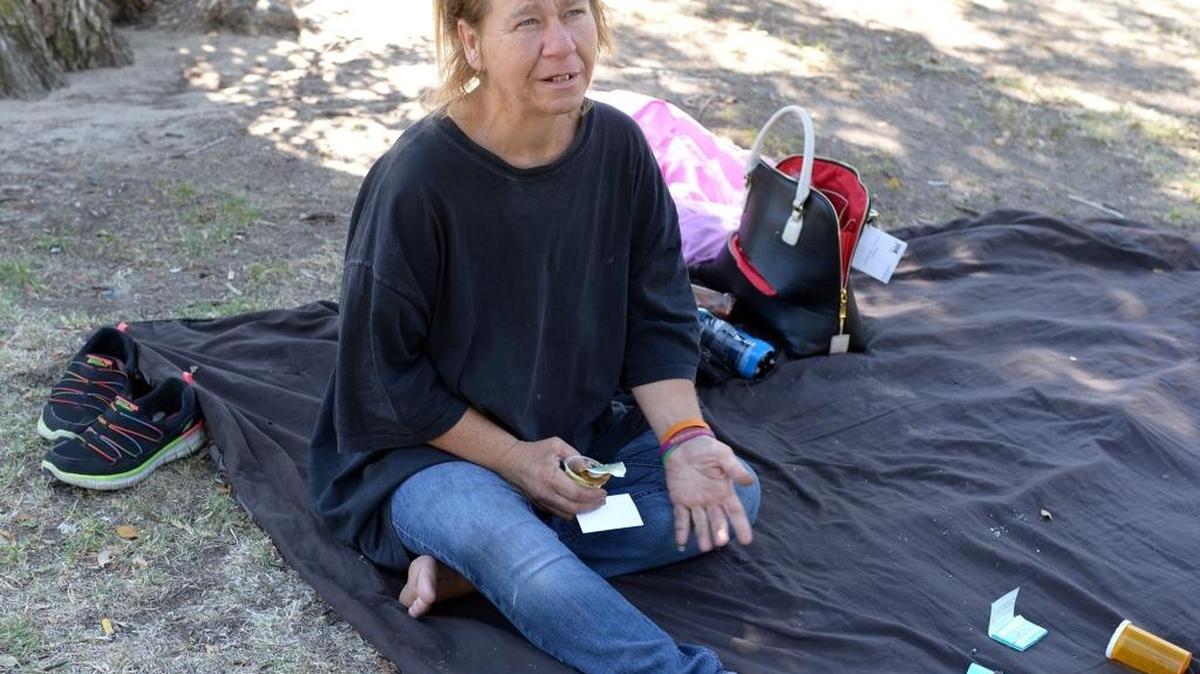 
Justina Sanders, a homeless woman, is pictured Friday afternoon at Enslen Park. Sanders spends time at the park during the day and says she sleeps in the backyards of vacant homes at night.
